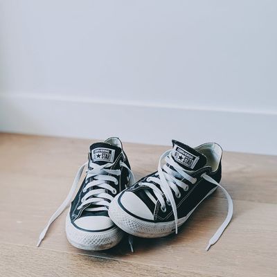 A pair of clean black running shoes on dark floor