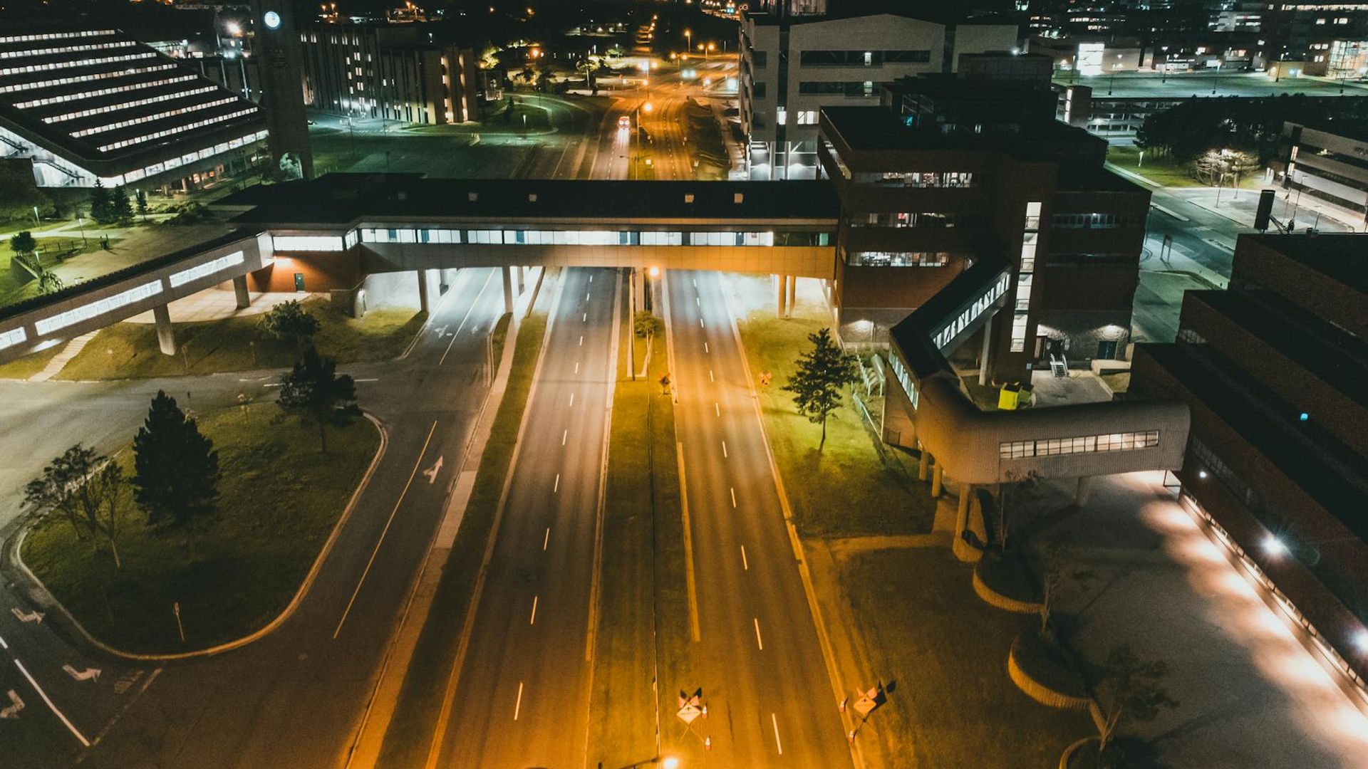 A wide panoramic view of an empty modern fitness studio with soft neon lighting