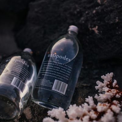 Clear glass water bottle reflecting neon lavender light sources