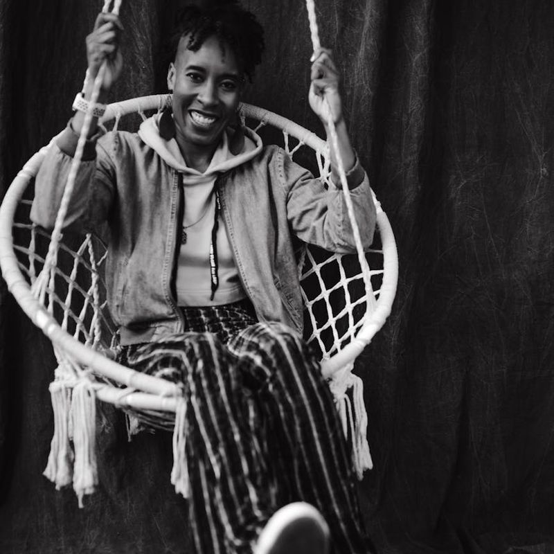 Person doing dynamic arm swings in a bright minimalist studio